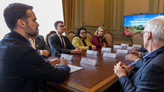 Diversas pessoas sentadas a uma mesa em reunião para assinatura do Decreto do Bioma Pampa